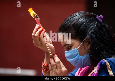 Kathmandu, Nepal. August 2020. Eine nepalesische Hindu-Frau bietet Lord Shiva rituelle Gebete während des Teej-Festes an, während sie Gesichtsbedeckung inmitten der Coronavirus-Krise (COVID-19) trägt.während dieses Festes beobachten Hindu-Frauen ein ganztägiges Fasten und beten für ihre Ehemänner und für ein glückliches Eheleben. Diejenigen, die unverheiratet sind, beten für einen guten Mann. Kredit: SOPA Images Limited/Alamy Live Nachrichten Stockfoto