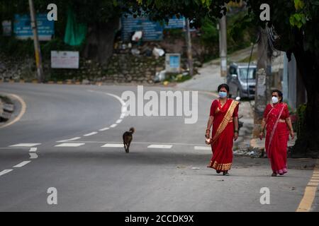 Kathmandu, Nepal. August 2020. Nepalesische Hindu-Frauen gehen während des Teej-Festivals inmitten der Krise des Coronavirus (COVID-19) die Straße entlang und tragen Gesichtsmasken.während dieses Festivals beobachten Hindu-Frauen ein ganztägiges Fasten und beten für ihre Ehemänner und für ein glückliches Eheleben. Diejenigen, die unverheiratet sind, beten für einen guten Mann. Kredit: SOPA Images Limited/Alamy Live Nachrichten Stockfoto