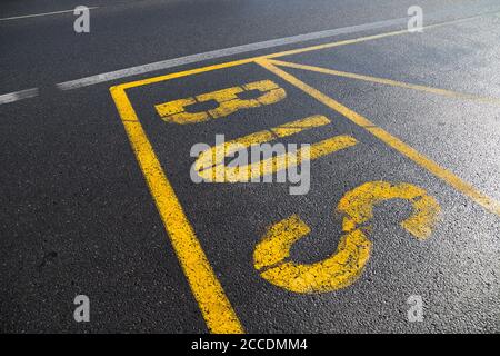 Farbe auf der Straße als Markierung von Büste Stop und Bahnhof. Gelbe Linien und TEXTBUS. Ort für öffentliche Verkehrsmittel auf der Straße. Stockfoto