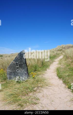 Geschnitzte Felsmarkierung für den Südwestküstenweg, der durch das Duneland bei Hayle in Nord-Cornwall führt. Stockfoto