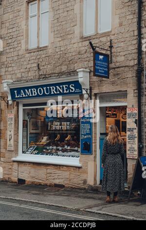 Stow-on-the-Wold, Großbritannien - 10. Juli 2020: Frau, die auf einer Straße steht und darauf wartet, die Metzgerei Lambournes in Stow-on-the-Wold, einer Marktstadt in Cotsw, zu betreten Stockfoto