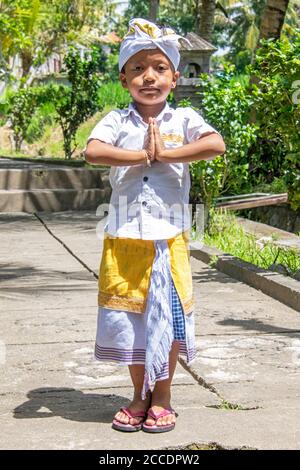 Zu den traditionellen balinesischen Kleidern für formelle Anlässe gehört ein Sarong, der mit einem Liederschmuck und einem Kopfschmuck, der als Udeng für Männer bezeichnet wird, gebunden und an Ort und Stelle gehalten wird. Stockfoto