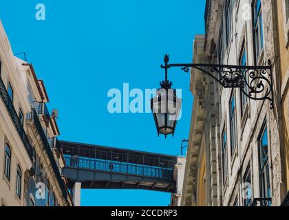 Detail eines alten Lamp Post mit dem Aufzug Santa Justa auf dem Hintergrund in der Stadt Lissabon, Portugal Stockfoto