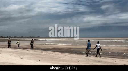 Die Fischer laufen auf ihrem Weg am Strand entlang und helfen, Fischernetze einzuziehen. Ghana Shama Strand außerhalb Takoradi. Stockfoto