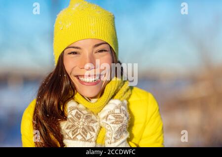 Winter Asian Frau lächelnd bei kaltem Wetter Mode-Accessoires für den Winter: Gelbe Mütze und Strickschal, Wollhandschuhe, Daunenjacke. Glückliches Mädchen genießen Stockfoto