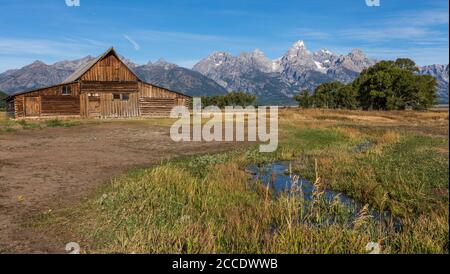 Ein kleiner Bach führt zur Molton Scheune auf Mormon Rudern Sie vor den Teton Bergen im Grand Teton National Parken Stockfoto