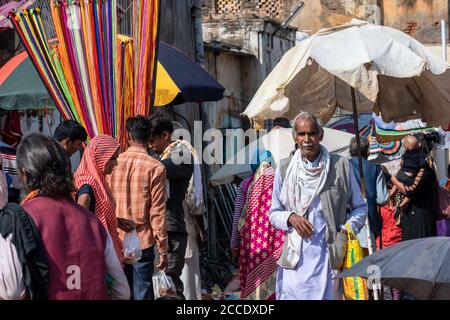 Orchha, Madhya Pradesh, Indien - März 2019: Ein älterer indischer Mann, der auf einem überfüllten und bunten Markt in der Stadt Orchha läuft. Stockfoto
