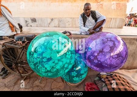 Orchha, Madhya Pradesh, Indien - März 2019: Ein indischer männlicher Straßenhändler, der Luftballons von seinem Fahrrad im Dorf Orchha verkauft. Stockfoto