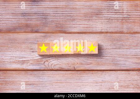 Holzblöcke mit dem fünf-Sterne-Symbol. Kundenerfahrungsumfrage und Konzept für Zufriedenheitsfeedback Stockfoto