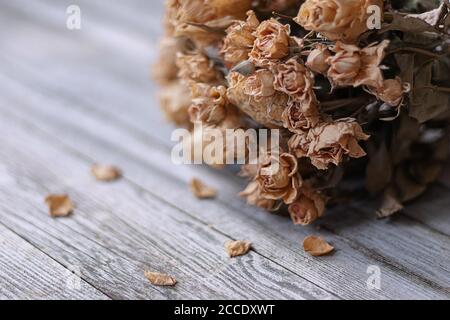 Bündel getrockneter Rosen auf Holztisch, nostalgische Erinnerungen an die Vergangenheit Stockfoto