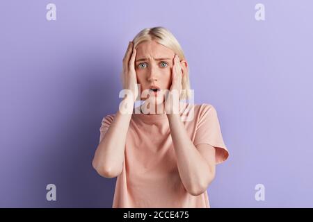 Ernsthafte blonde Mädchen hat Kopfschmerzen, Nahaufnahme Porträt, Emotion und Gefühl. Nahaufnahme Porträt. studio shot.Krankheit Stockfoto