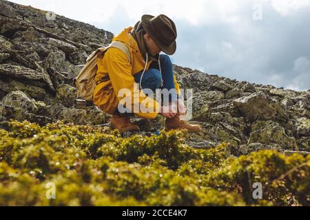 Wanderer Binden Stiefel Schnürsenkel auf dem Berg, volle Länge Seitenansicht Foto. Freizeit, Freizeit Stockfoto