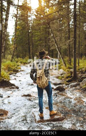 Junger großer Mann hält eine Tasse und Trinkwasser, volle Länge Rückansicht photo.free mal Stockfoto