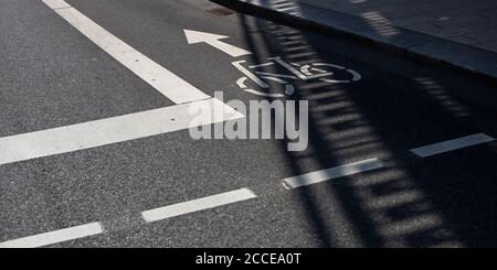 Fahrradschild auf der Straße zu trennen Radweg von Autoverkehr mit Pfeil und anderen Linien auf dem Asphalt Stockfoto