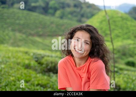 Schöne Brünette Mädchen posiert in der Mitte des Teetals zwischen grünem Tee Büsche Stockfoto