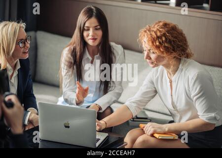 Schöne clever niedlich charmant attraktive elegante weibliche Geschäftspartner haben Online-Treffen mit potenziellen Investor, sammeln im Kreis in der Nähe von Tisch wi Stockfoto