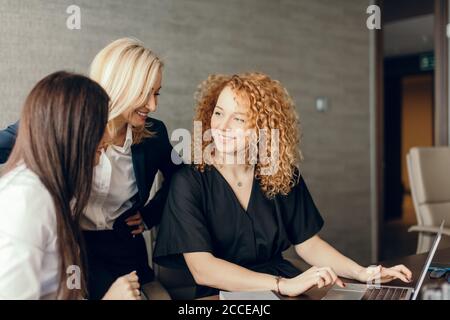 Schöne clever niedlich charmant attraktive elegante weibliche Geschäftspartner haben Online-Treffen mit potenziellen Investor, sammeln im Kreis in der Nähe von Tisch wi Stockfoto