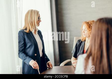Geschäftskonzept für Frauen. Junge blonde Expertin macht eine Präsentation bei einem Treffen im Büro. Stockfoto