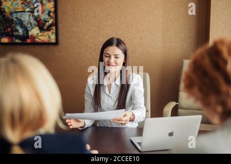 Frau Job Antragsteller mit einem Interview mit zwei weiblichen Unternehmensexperten im Büro des großen Unternehmens. Zwei junge schöne Frauen, die Durchführung einer Arbeit interv Stockfoto