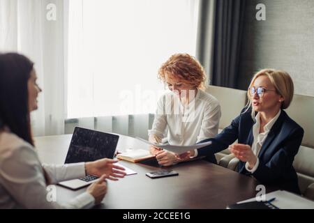 Frau Job Antragsteller mit einem Interview mit zwei weiblichen Unternehmensexperten im Büro des großen Unternehmens. Zwei junge schöne Frauen, die Durchführung einer Arbeit interv Stockfoto