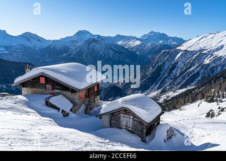 Europa, Schweiz, Wallis, Belalp, eingeschneite Holzhütten vor der Bergkulisse der Walliser Alpen Stockfoto