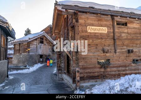 Europa, Schweiz, Wallis, Blatten, Mutter und Sohn auf einem Winterspaziergang durch die Altstadt von Blatten Stockfoto