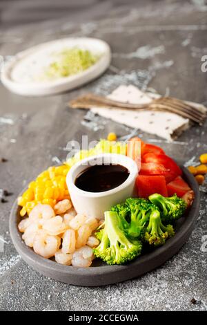 Zutaten der Küche auf dem Teller. Draufsicht. Gemüse, Gewürze, Garnelen, Sauce zum Kochen. Stockfoto