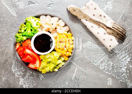 Zutaten der Küche auf dem Teller. Draufsicht. Gemüse, Gewürze, Garnelen, Sauce zum Kochen. Stockfoto