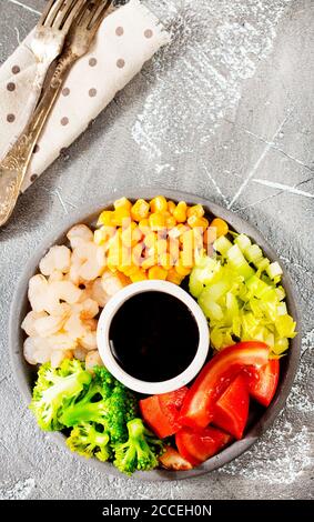 Zutaten der Küche auf dem Teller. Draufsicht. Gemüse, Gewürze, Garnelen, Sauce zum Kochen. Stockfoto