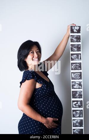 Schwangere Frau hält Baby-Scans Stockfoto