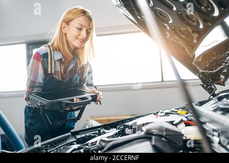 Happy faires Mädchen arbeitet mit einem Auto-Diagnose-System erkennt einen Fehler Zustand, Nahaufnahme Foto Stockfoto