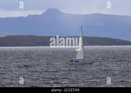 Eine Segelyacht auf Inner Sound mit der Isle of Rassay und Dùn Caan in der Ferne. West Highlands, Schottland, Großbritannien Stockfoto