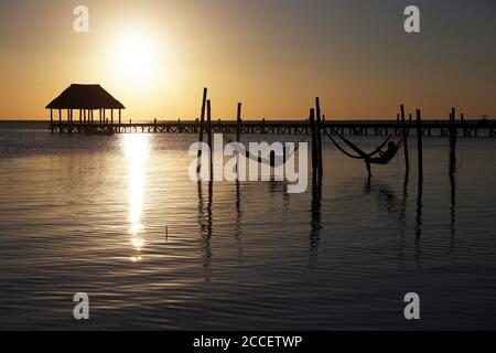 Touristen Sonnenbaden am Strand von Holbox neben einigen Hängematten. Stockfoto