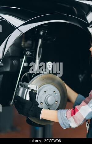 Frau Hände halten Bremsscheibe. Frau Reparatur eines Reifens des Autos, Nahaufnahme abgeschnitten Foto Stockfoto