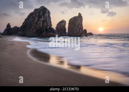 Portugal Ursa Beach. Das wunderschöne Meer stapelt Felsen im Sonnenuntergang Licht. Weiße atlantikwellen am leeren Sandstrand. Stockfoto