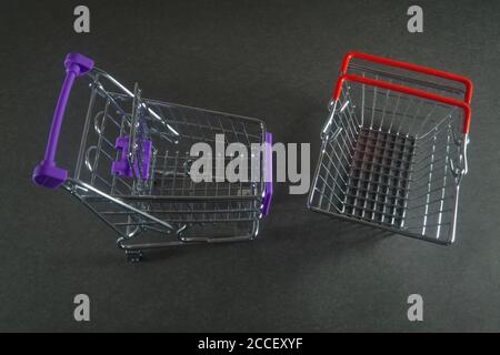 Zwei leere Lebensmittelkarren auf einem dunkelgrauen Hintergrund Nahaufnahme. Stockfoto