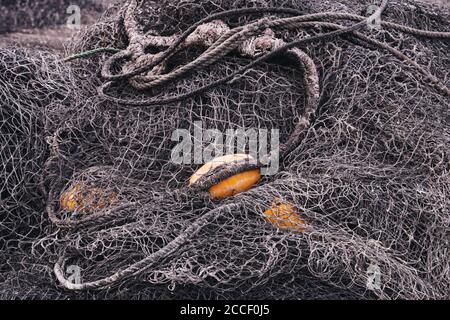 Ein Haufen schwarzer Fischernetze mit gelben Schwimmern Stockfoto