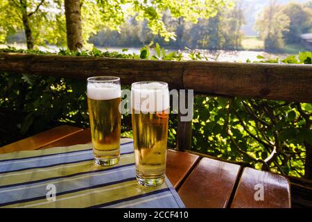 Gefüllte Biergläser im Biergarten vom Gasthaus zum Bruckenfischer, Isar, Dürnstein bei Schäftlarn, Oberbayern, Bayern, Deutschland Stockfoto