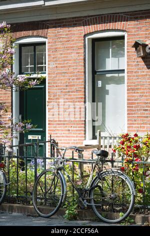 Fahrrad vor einem typischen holländischen Haus in Groningen, Niederlande Stockfoto