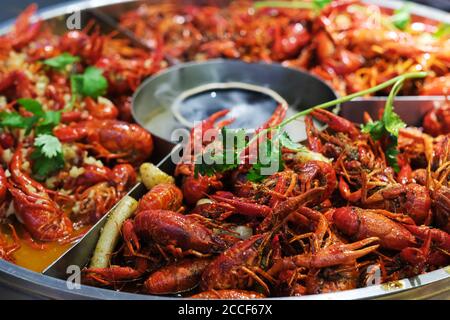 Nahaufnahme viele gedämpfte würzige rote Sumpfkrebse in großen Topf. Unschärfe Hintergrund. Beliebtes Essen in China Stockfoto