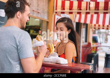 Ein glückliches Paar, das Sandwiches in einem typischen Retro-Café in Florida isst. Cuba Sandwich lokale Küche. Sommer Reise Tourist Lifestyle junge asiatische Frau lächelnd Stockfoto