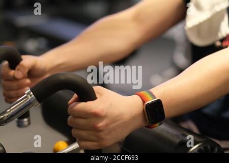 Nahaufnahme Mann Arm trägt Smart Watch, Training auf Fitnessgeräten. Verwischen Hintergrund Stockfoto