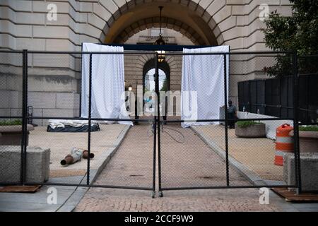 Das Andrew W. Mellon Auditorium, das sich im Besitz der Bundesregierung befindet, wird im Vorfeld der Republikanischen Nationalkonvent von 2020, die den Veranstaltungsort als Hauptdrehscheibe für Reden und Personal in Washington, DC, am 21. August 2020 inmitten der Coronavirus-Pandemie nutzen will, hinter zeitweiligen Metallzäunen gesehen. Präsident Trump wird die republikanische Nominierung für den Präsidenten vom South Lawn des Weißen Hauses akzeptieren, da andere Kongressveranstaltungen auch auf Bundeseigentum stattfinden C Ethik-Experten haben Bedenken geäußert, dass dies möglicherweise Bundeskorruptionsgesetze verletzt, die die Verwendung von Regierung einschränken Stockfoto