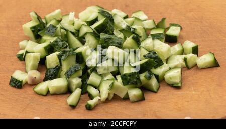 Gurke in Scheiben auf Holzhintergrund. In den Prozess der Zubereitung von Salat Stockfoto