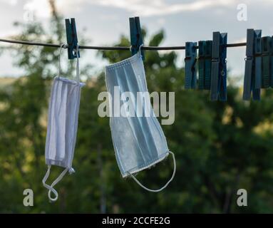 Gebrauchte Maske gewaschen und auf das Kabel zum Trocknen. Coronavirus-Konzept Stockfoto