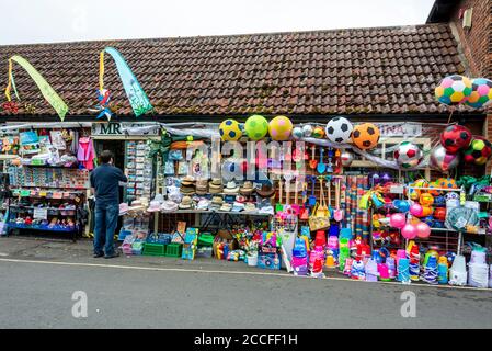 Ein traditionelles englisches Spielzeuggeschäft am Meer mit Strandspielzeug, Eimern, Spaten und Strandbällen zum Verkauf für den Strand in Wells-next-the-Sea in Norfolk, Großbritannien, Stockfoto