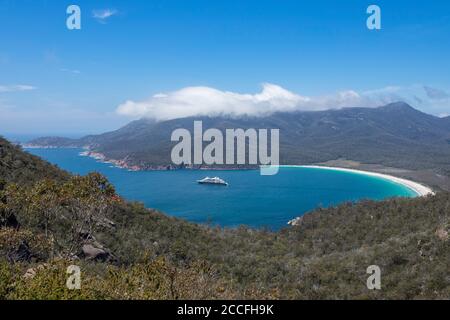 Blick vom Wineglass Bay Lookout, mit Ponant's Le Laperouse Expeditionsschiff vor Anker in der Bay, Freycinet National Park, Tasmanien, Australien Stockfoto