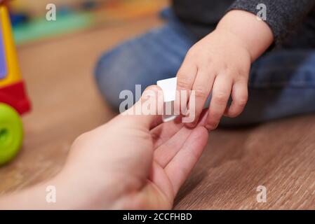 Papa gibt dem Kind eine Figur zum Falten Sortierer Spielzeug, Hände close-up, pädagogische Spiele für Kinder. Stockfoto