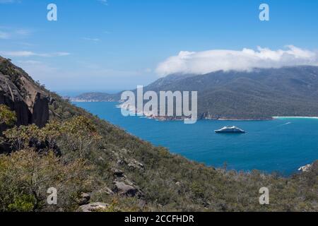 Blick vom Wineglass Bay Lookout, mit Ponant's Le Laperouse Expeditionsschiff vor Anker in der Bay, Freycinet National Park, Tasmanien, Australien Stockfoto