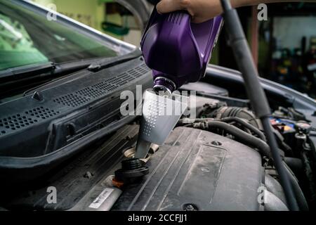 Hand Nachfüllen Motor Schmieröl auf Privatwagen DIY bei Zu Hause Stockfoto